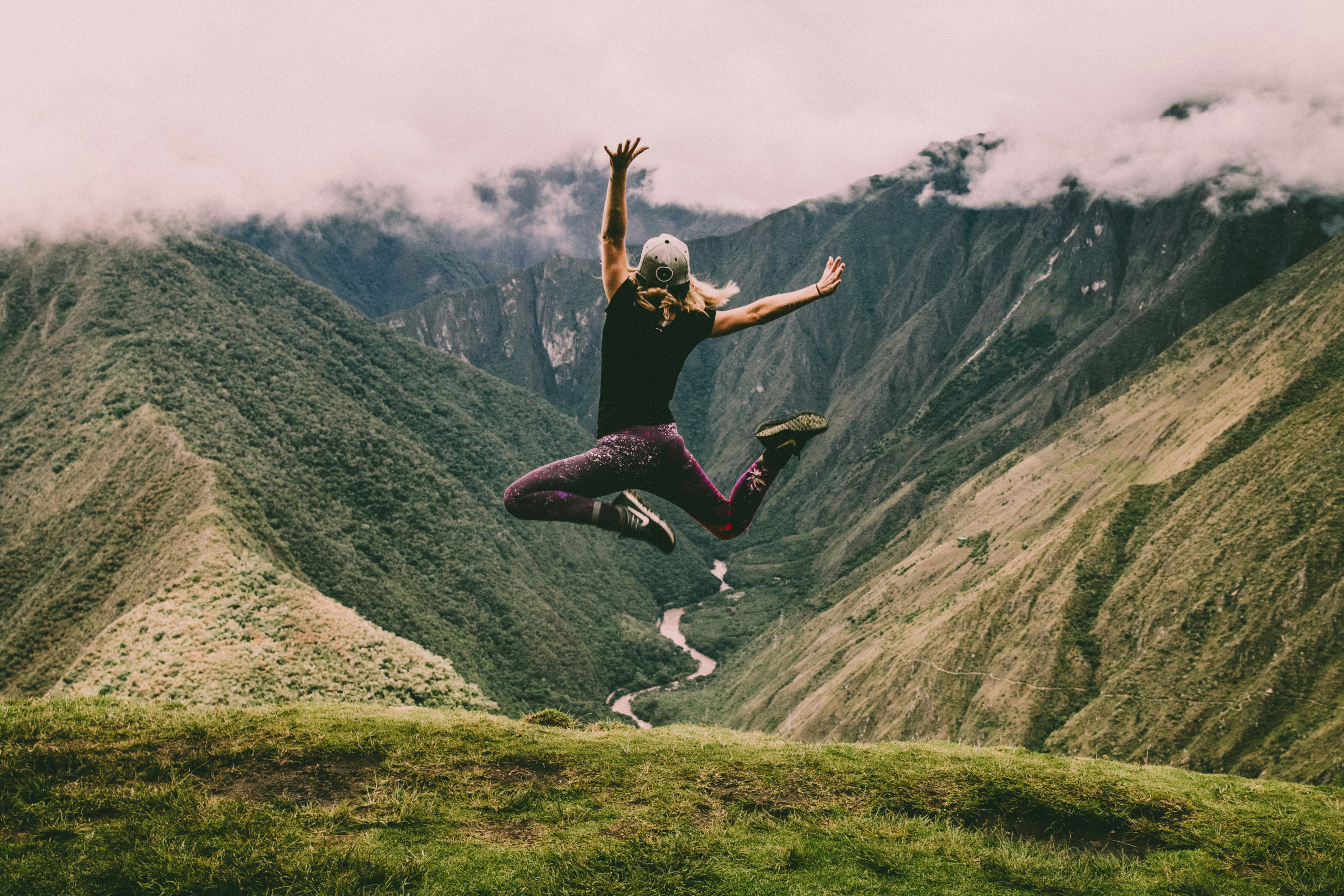 women jumping in front of mountains